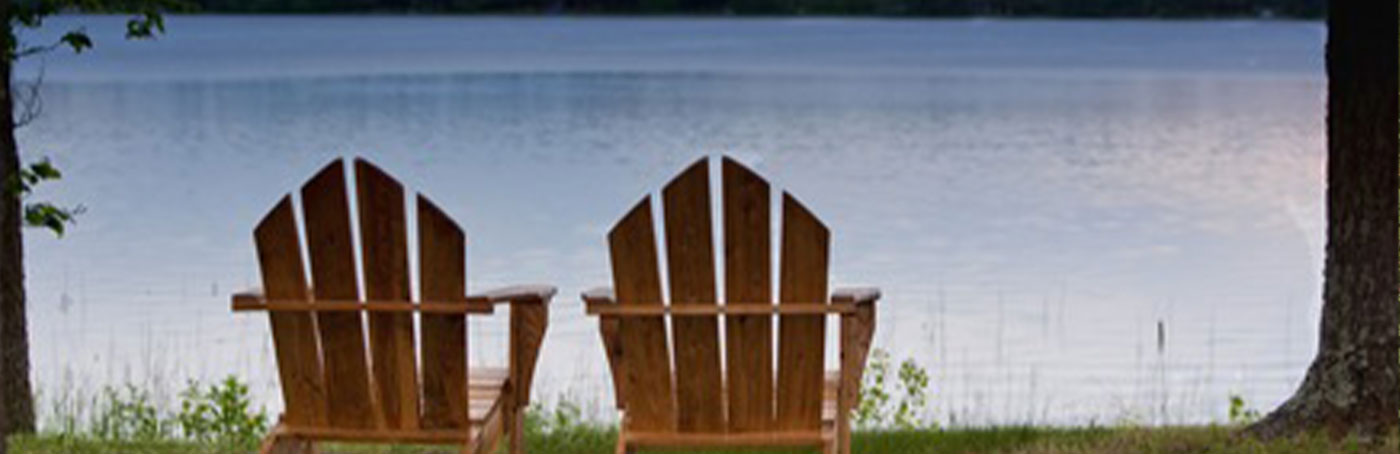 two chairs empty near a lake